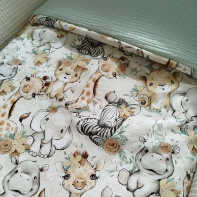 Colcha de bebé com desenhos de animais de safari cartoon e fundo azul esverdeado.