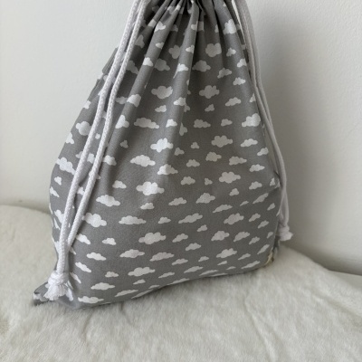 Mochila saco cinza com padrão de nuvens brancas e cordões brancos
