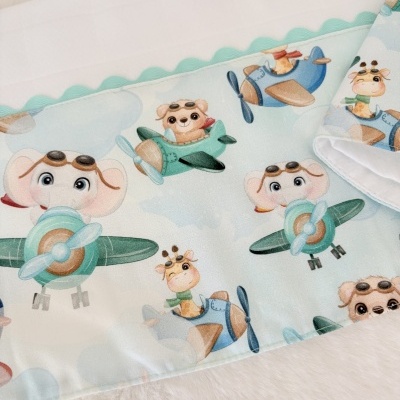 Tecido infantil com padrão de animais em aviões coloridos em fundo azul claro