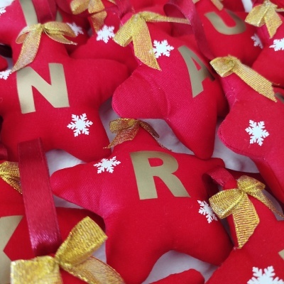 Estrelas vermelhas de tecido com letras douradas e laços dourados