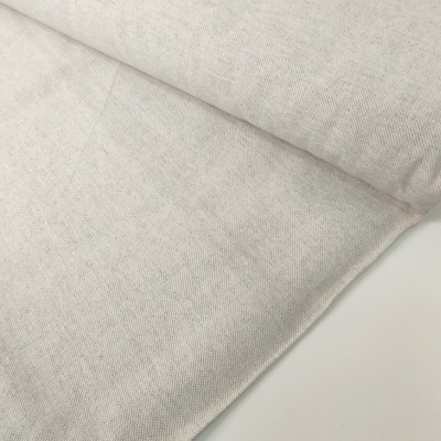 Rolo de tecido bege claro com textura sobre superfície branca