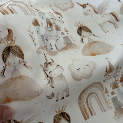 Tecido branco com estampa infantil de unicórnios, princesas, castelos e arco-íris em tons pastel.