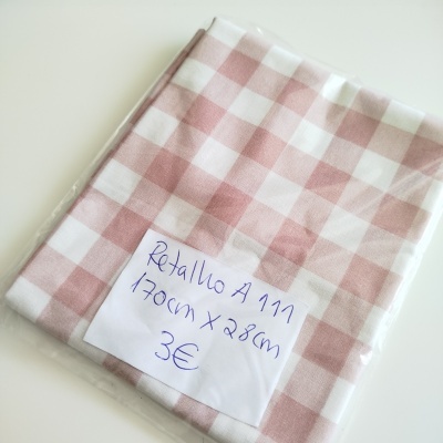 Retalho de tecido rosa e branco quadriculado com etiqueta manuscrita em embalagem plástica.