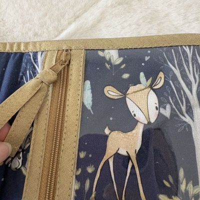 Capa ou bolsa de tecido com fecho e padrão infantil com cervo e folhas.