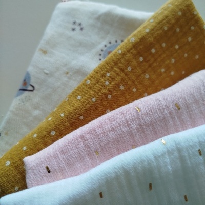 Quatro tecidos de algodão coloridos com padrões diferentes empilhados.