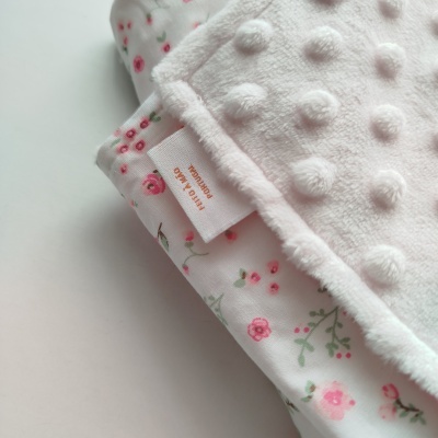Fralda de bebé com padrão floral e tecido felpudo branco texturizado