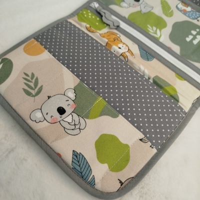 Estojo tecido acolchoado com estampados de coala, folhas e pontos