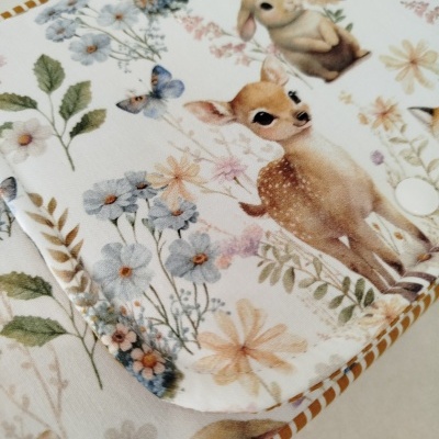 tecido com padrão de animais e flores em tons suaves