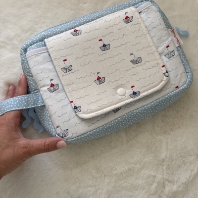 Bolsa de tecido azul com bolinhas e bolso com padrão de barcos coloridos