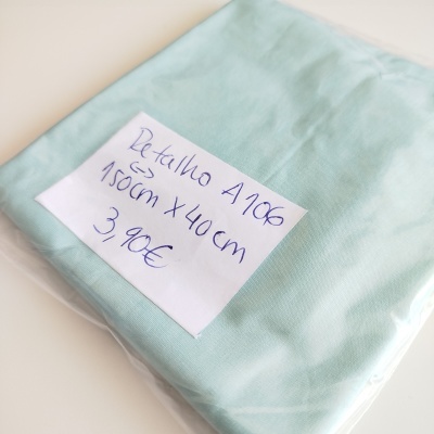 Tecido azul claro embalado com etiqueta manuscrita e preço