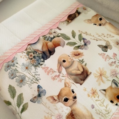 Fralda de tecido branca e estampada com animais e flores, borda rosa