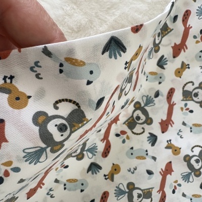 Tecido branco com padrão infantil de animais coloridos