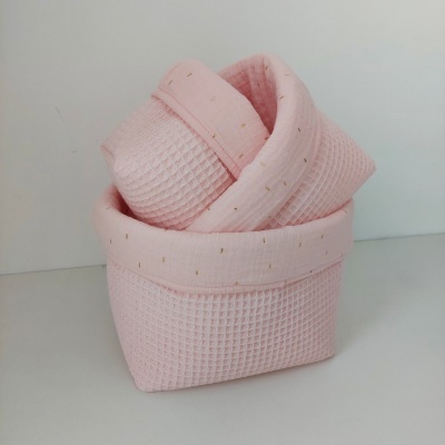Cesta de tecido rosa com textura tipo waffle e pequenos pontos dourados