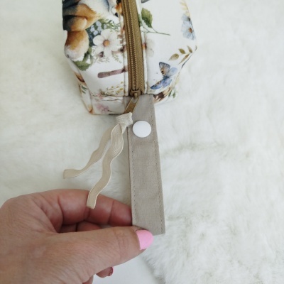 Estojo floral com alça bege e fecho dourado