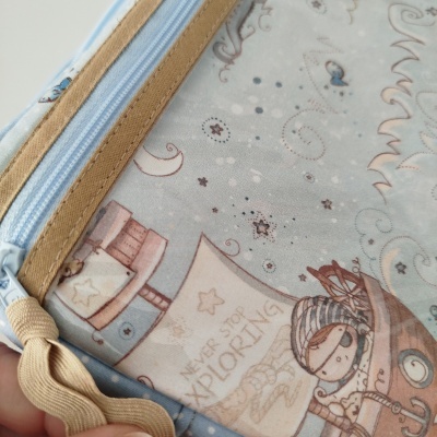 Estojo azul claro com padrão infantil e texto 'NEVER STOP EXPLORING'