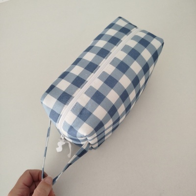 Bolsa pequena xadrez azul e branco com fecho de correr e alça estreita