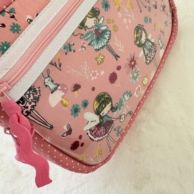 Bolsa rosa com padrão de fadas e flores, fecho zip rosa.