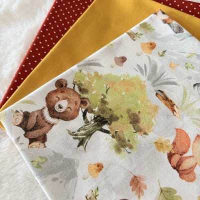 Três tecidos dobrados com estampados e cores sólidas sobre superfície branca.