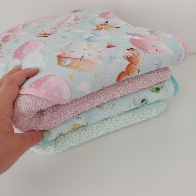 Toalhas infantis coloridas e estampadas empilhadas com padrão de animais e balões