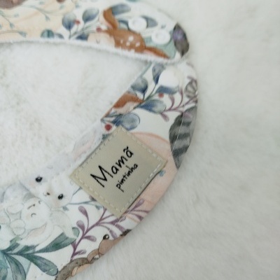 Babete colorido para bebé com padrão de animais e plantas e etiqueta 