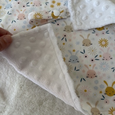 Manta ou cobertor branco com estampa de coelhos e flores em tons pastel