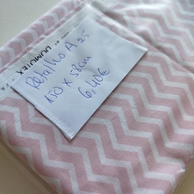 Rolinho de tecido rosa e branco com etiqueta manuscrita e etiqueta de tecido Domotex