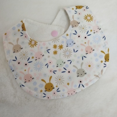 Babete redondo para bebé com estampa de coelhinhos e flores coloridas