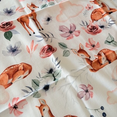 Tecido branco com padrão de veados, flores e folhas coloridas