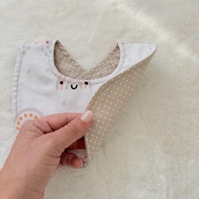 Babete para bebé branco com gotas coloridas e interior bege com pontos brancos