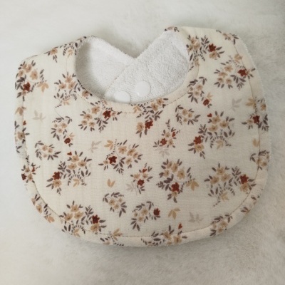 Babete para bebé com padrão floral e fecho de mola branco