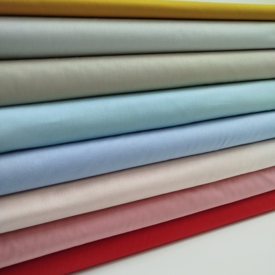 Tecidos de várias cores empilhados com textura lisa