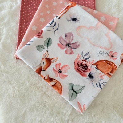 Três tecidos estampados sobre superfície branca felpuda.