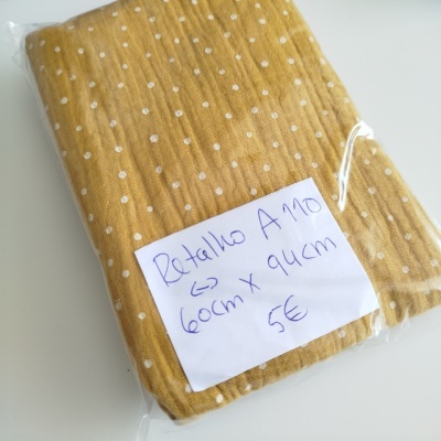 Retalho de tecido amarelo mostarda com bolinhas brancas embalado em plástico e nota manuscrita.