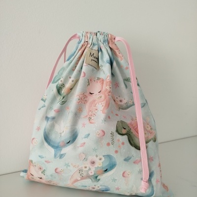 Saco de tecido com padrão colorido de animais marinhos em tons pastel e cordões rosa