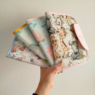 Quatro capas em tecido com padrões infantis e bordas coloridas