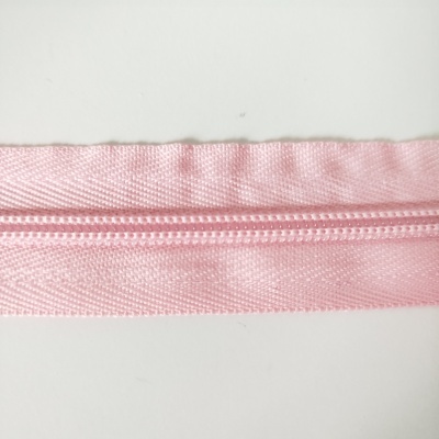 Fecho éclair rosa claro de tecido sintético com dentes plásticos