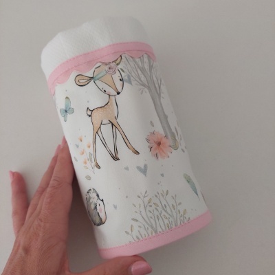 Fralda de tecido branco com desenhos infantis em tons suaves e bordas rosas