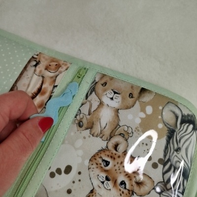 Carteira infantil com estampas de animais caricaturados e zíper verde claro