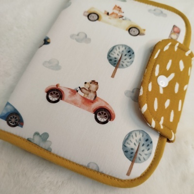 Estojo infantil branco com estampado de ursos em carros e fecho amarelo com padrão