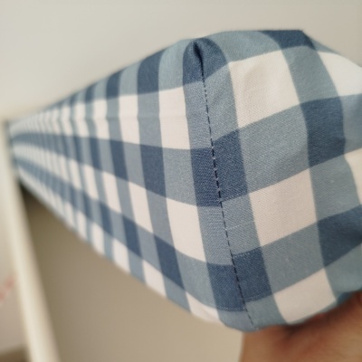 Capa de tecido azul e branco com padrão vichy e costura visível