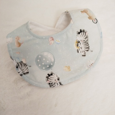 Babete de bebé azul com padrão de zebras e peixes