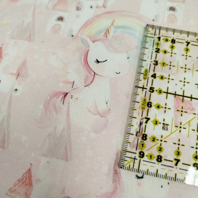 Tecido cor-de-rosa com unicórnios e castelos e régua transparente amarela