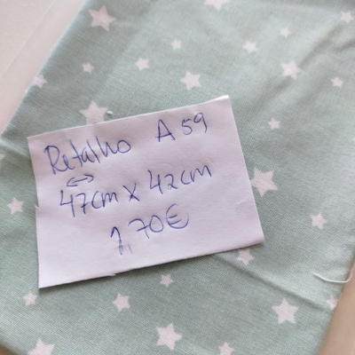 Retalho de tecido azul esverdeado com estrelas brancas e nota escrita à mão com medidas e preço