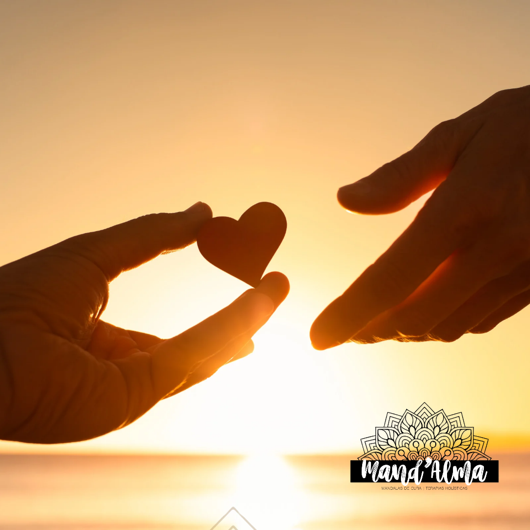 Duas mãos contra lumière do pôr-do-sol, com coração vermelho entre elas