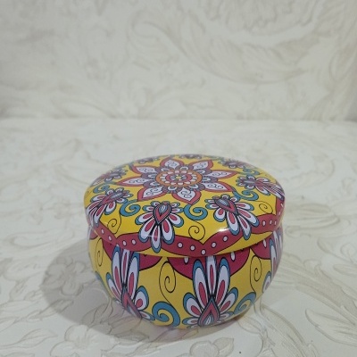 Caixa redonda de metal com padrão floral colorido