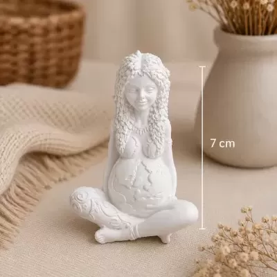 Estátua decorativa branca de mulher grávida sentada com pernas cruzadas e detalhes texturizados