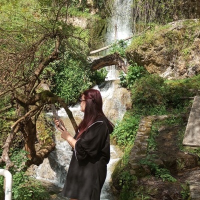 Vitimismo que te condiciona Mulher de vestido preto junto a cachoeira na natureza