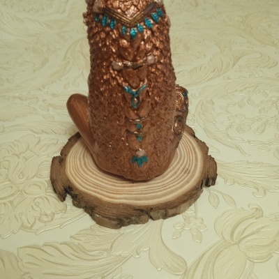 Estátua decorativa de elefante bronze com detalhes azuis sobre base de madeira