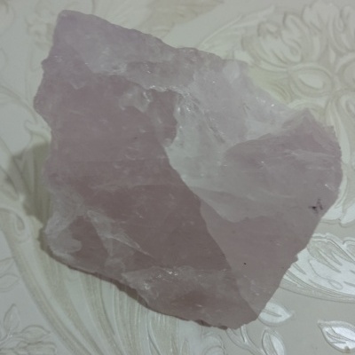 Pedra roxa de quartzo bruto sobre superfície decorada clara