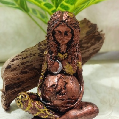Deusa de Gaia Estátua decorativa de mulher grávida em bronze com detalhes dourados e planta ao fundo